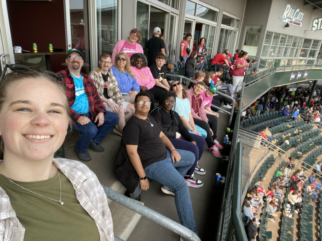 A group of people sitting in bleachers

Description automatically generated